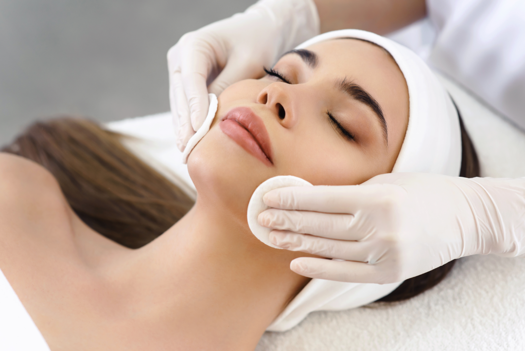 A professional preparing a client for a medspa chemical peel treatment.